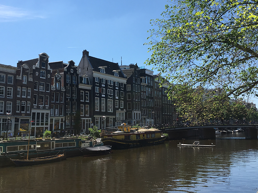 Giebelhäuser an einer Gracht samt Hausboot und Brücken - das ist wirklich typisch Amsterdam!