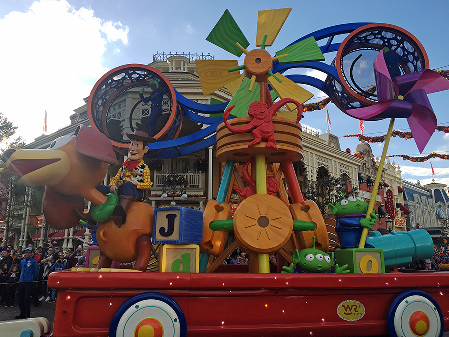 Buzz Lightyear und Woody folgen auf einem quietschebunten Spielzeugwagen für Toy Story.
