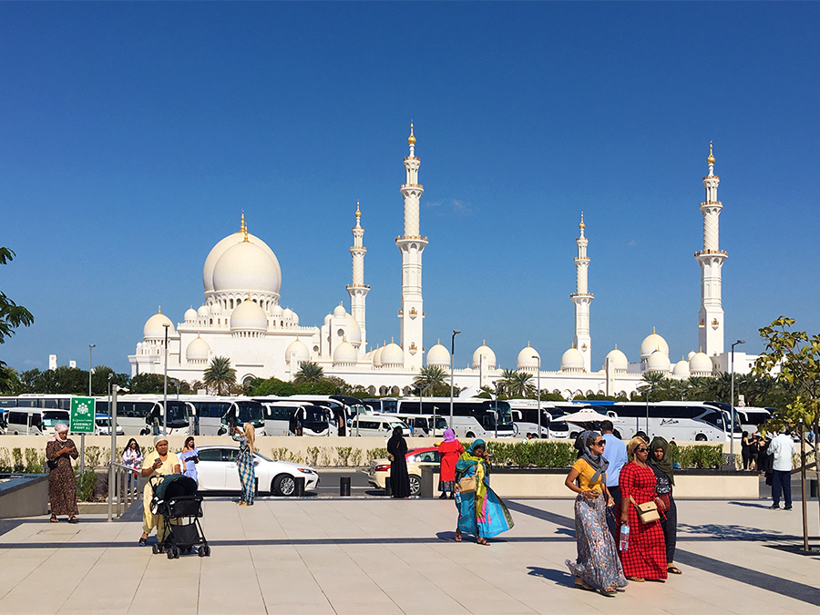 Elegant gekleidete Frauen in fließenden Gewändern und mit Kopftuch vor der Scheich-Zayid-Moschee.