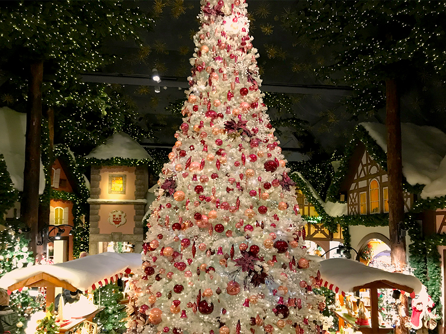 Ein riesiger, weißer, reich geschmückter Kunsttannenbaum steht in der Mitte des zentralen Raumes in Käthe Wohlfahrts Weihnachtsladen.