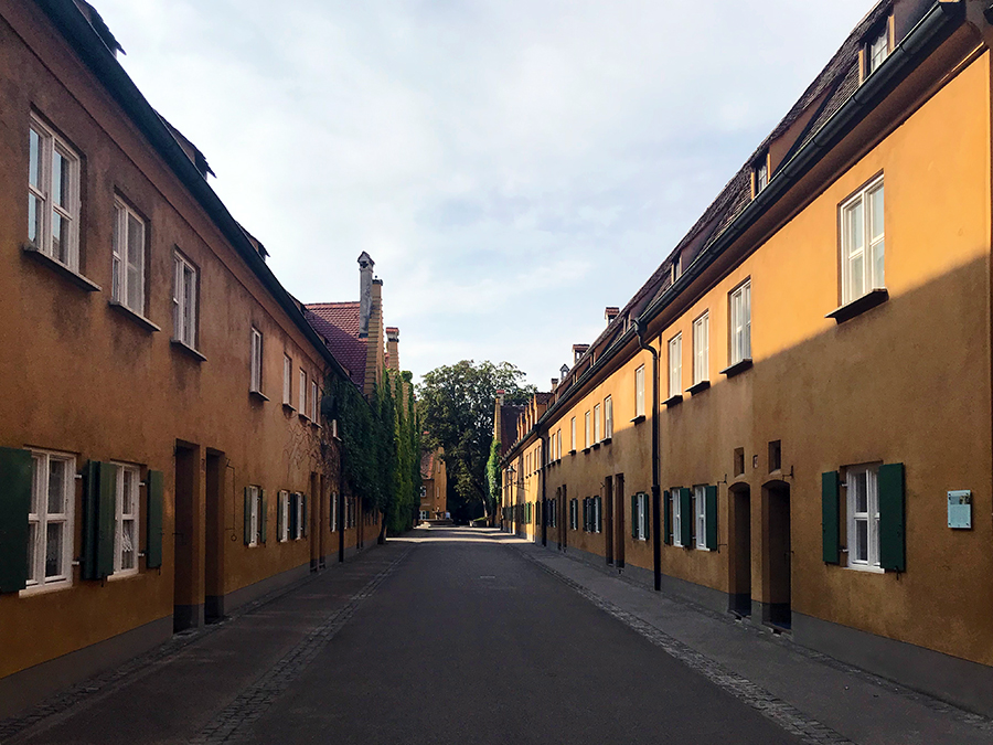 Typisch senffarbene Häuser in der Herrenstraße in der Fuggerei in Augsburg.