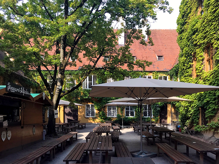 Der lauschige Biergarten in der Fuggerei in Augsburg, direkt rechts hinterm Eingang.
