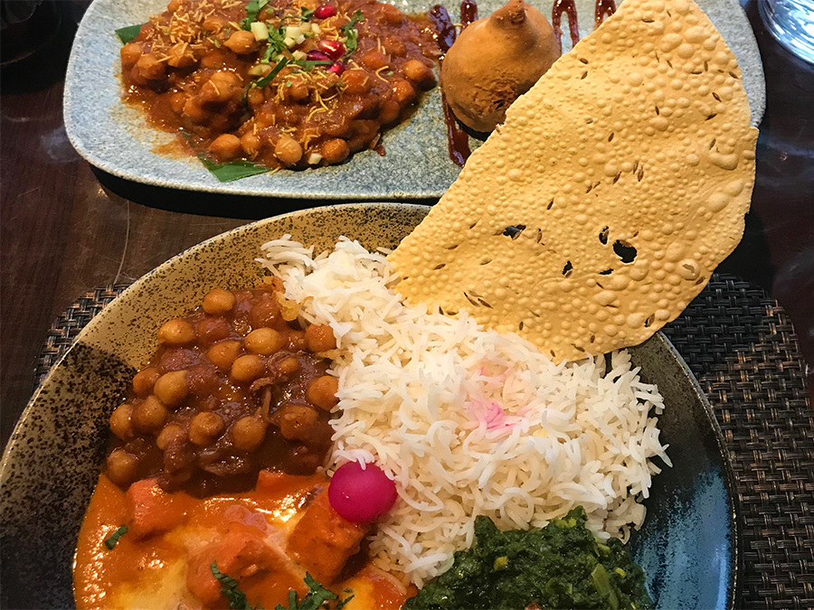 Paneer (indischer Hüttenkäse) in würzig-cremiger Tomatensauce, Kichererbsencurry, Spinat, gedämpfter Reis und knuspriges Papadam, dazu frittierte Samosas (mit Gemüse gefüllte Teigtaschen) - yummie!