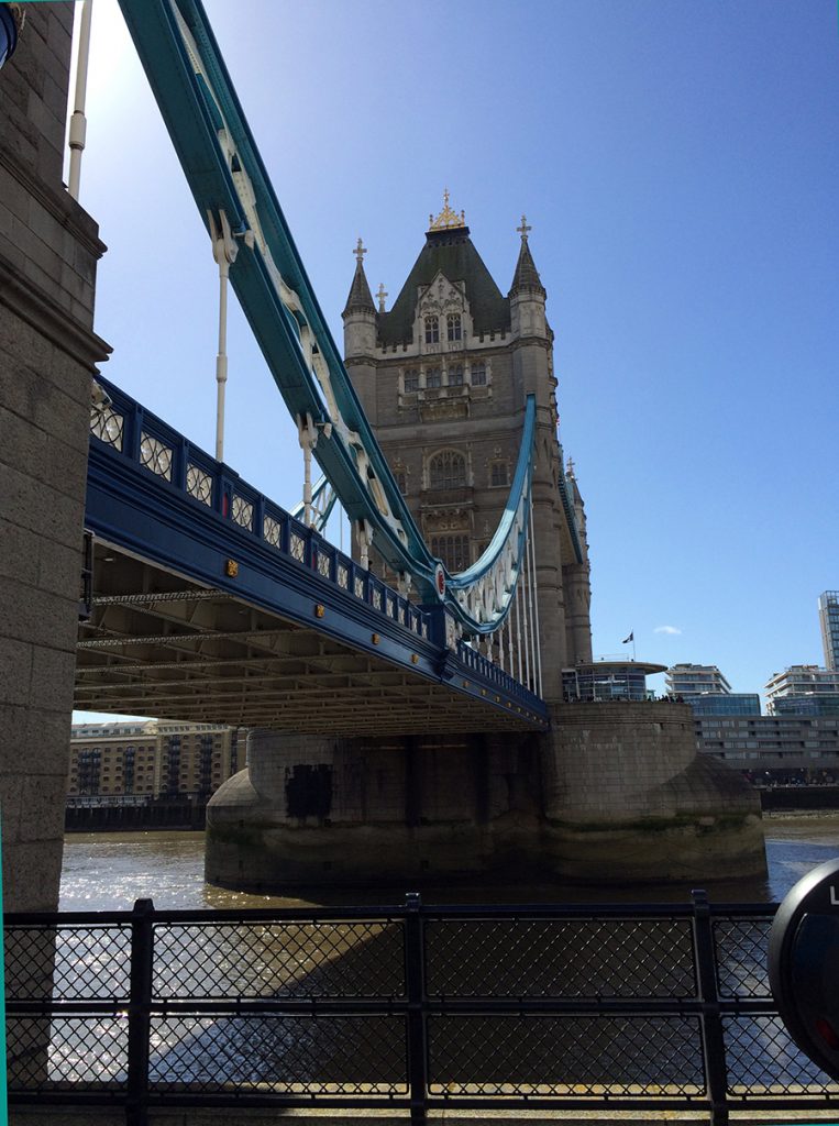 Sicht von der Promenade vor dem Tower auf den Nordturm der Tower Bridge vor einem typisch strahlenden, blauen, britischen Himmel.