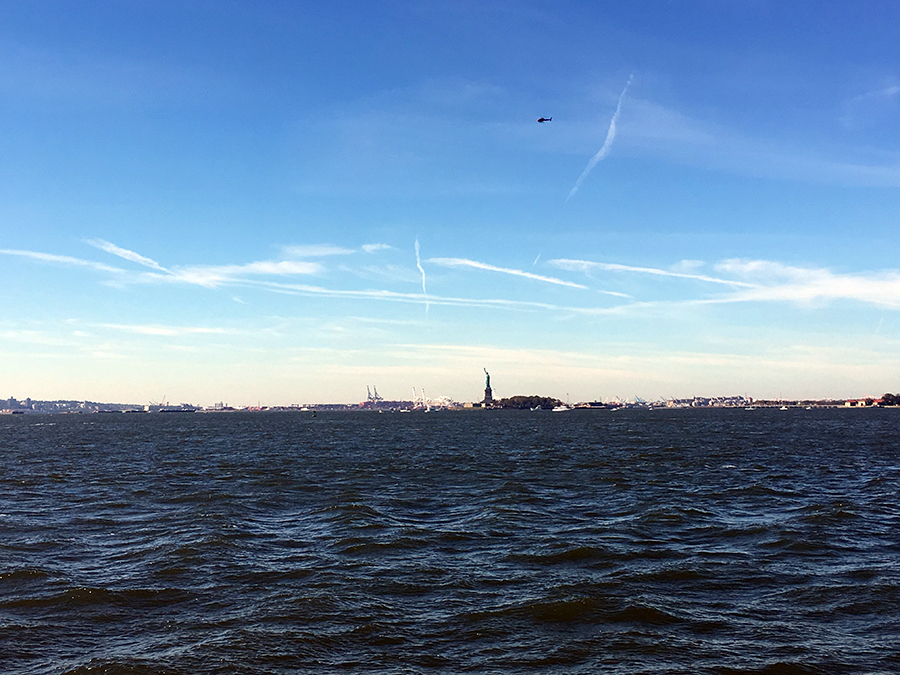 Ziemlich weit weg, die Freiheitsstatue, von unserer Bank am Pier.