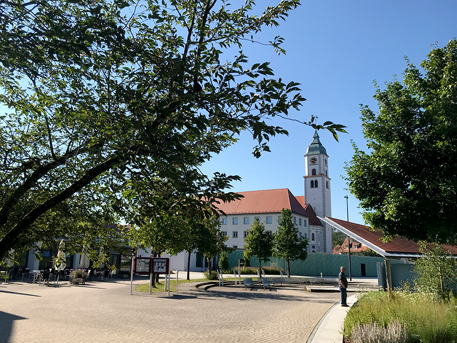 Vor dem Kurhaus von Bad Wurzach ist viel Platz für Kurkonzerte, mit Blick auf die Kirche St. Verena.